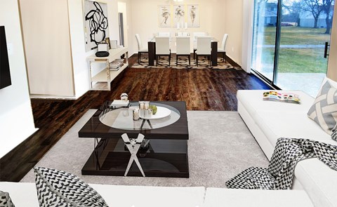 A modern living room with a glass coffee table and a white couch.