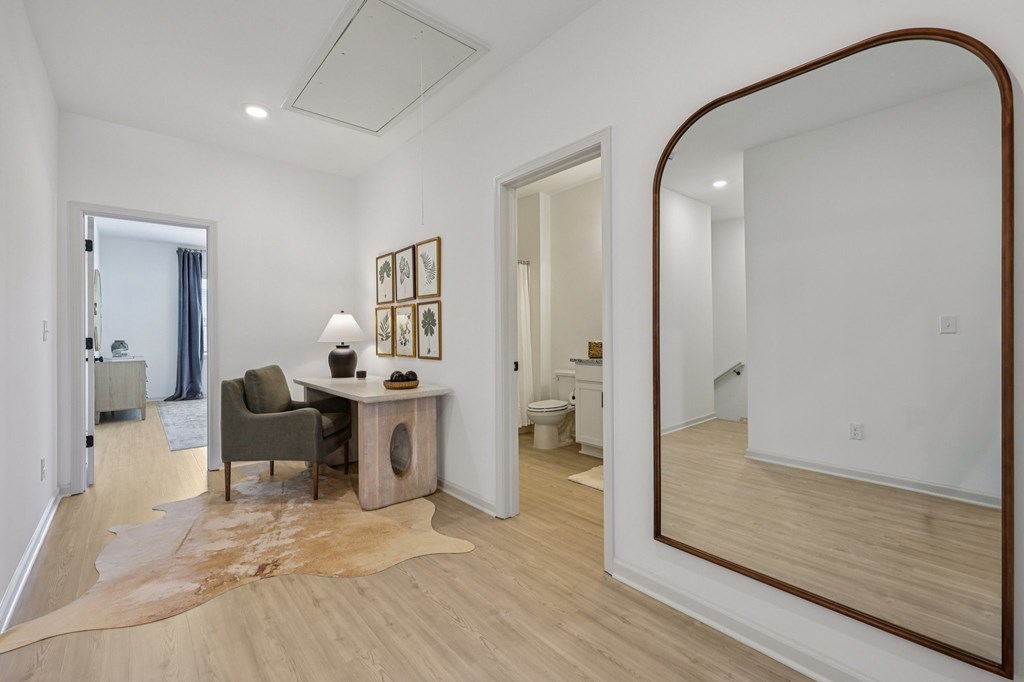 A room with a brown cowhide rug and a wooden desk with a chair.