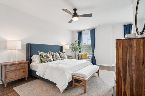 A bedroom with a large bed and a wooden dresser.