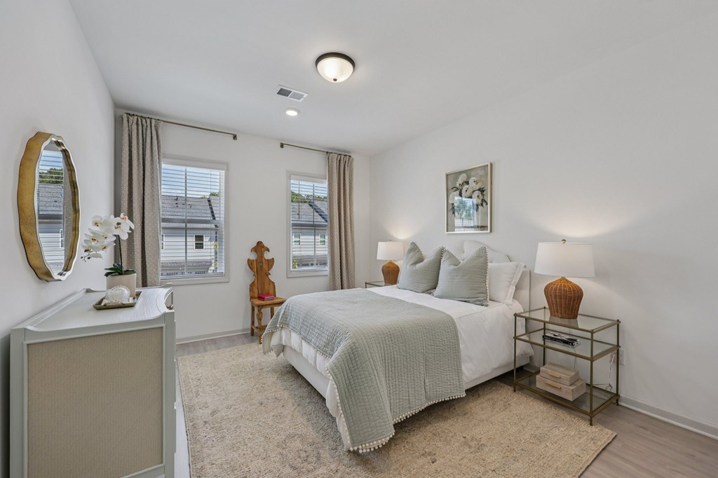 A bedroom with a bed, nightstand, and window.