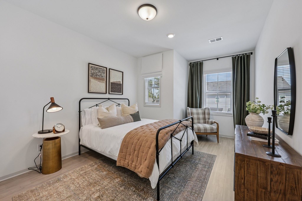 A bedroom with a large bed and a window with curtains.