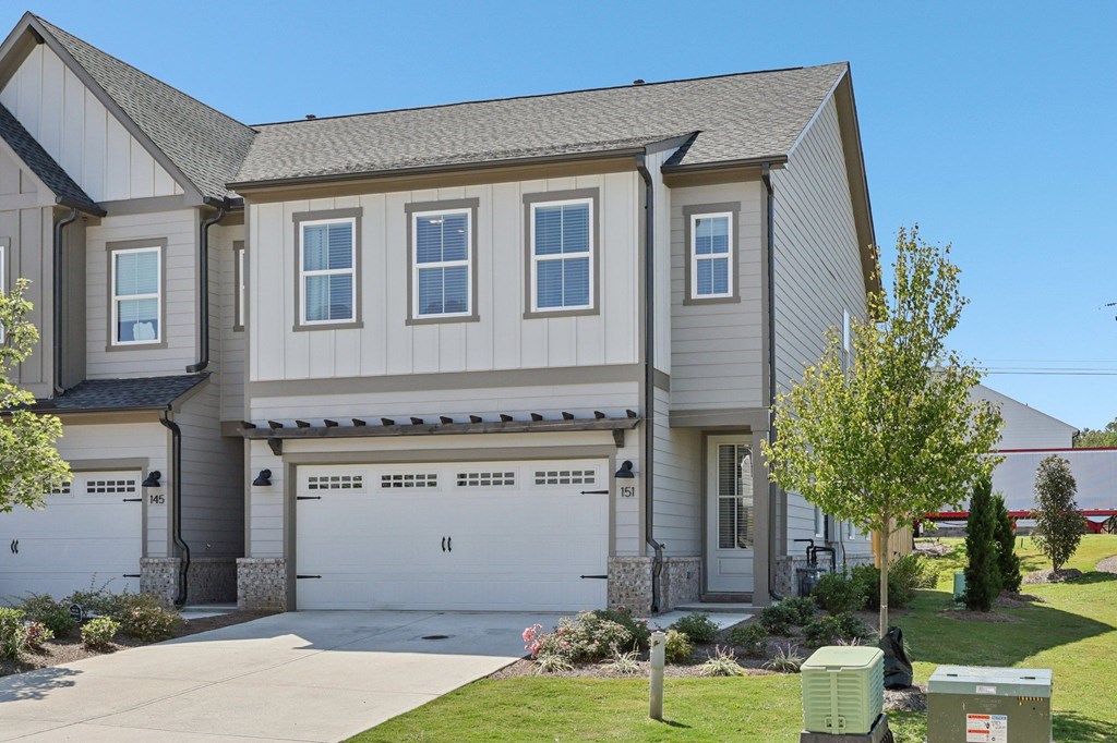 A two-story house with a garage and a driveway.