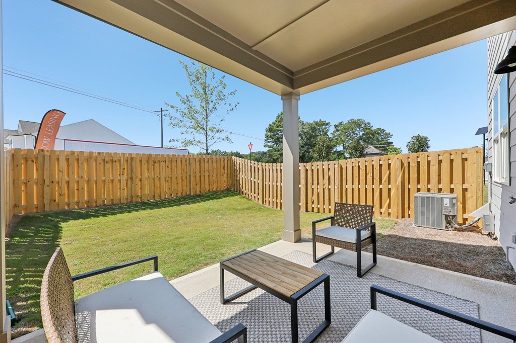 A patio with a table and chairs under a roof.
