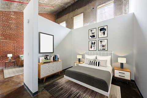 A bedroom with a bed, nightstands, and pictures on the wall.