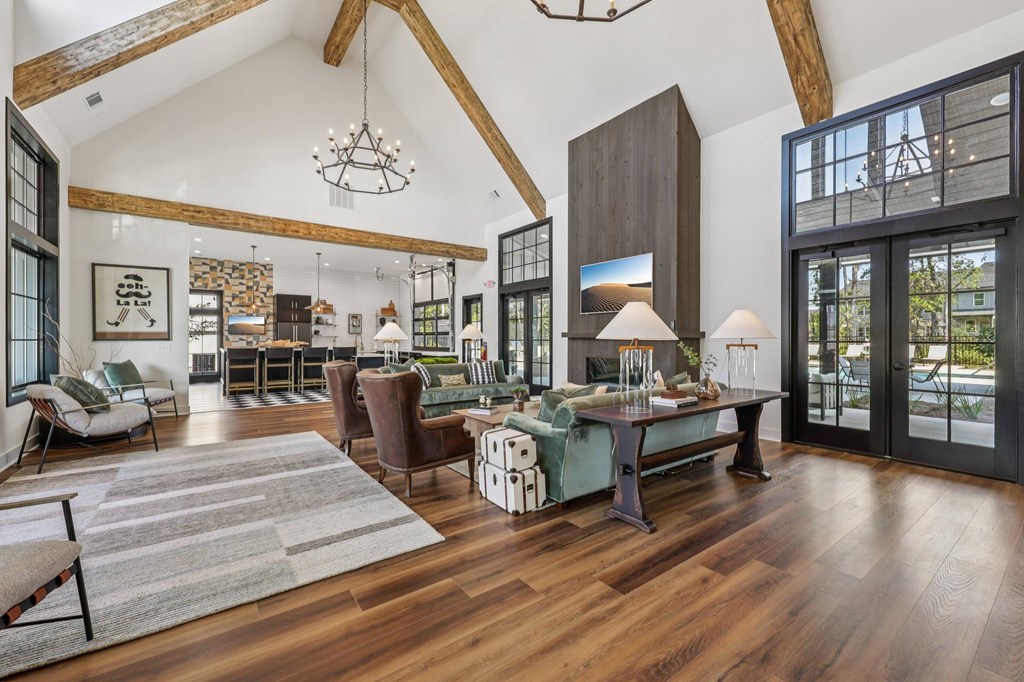 A large, open-concept living room with wooden floors and furniture.