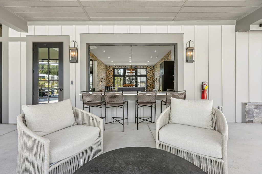 A white wicker chair is in front of a black table.