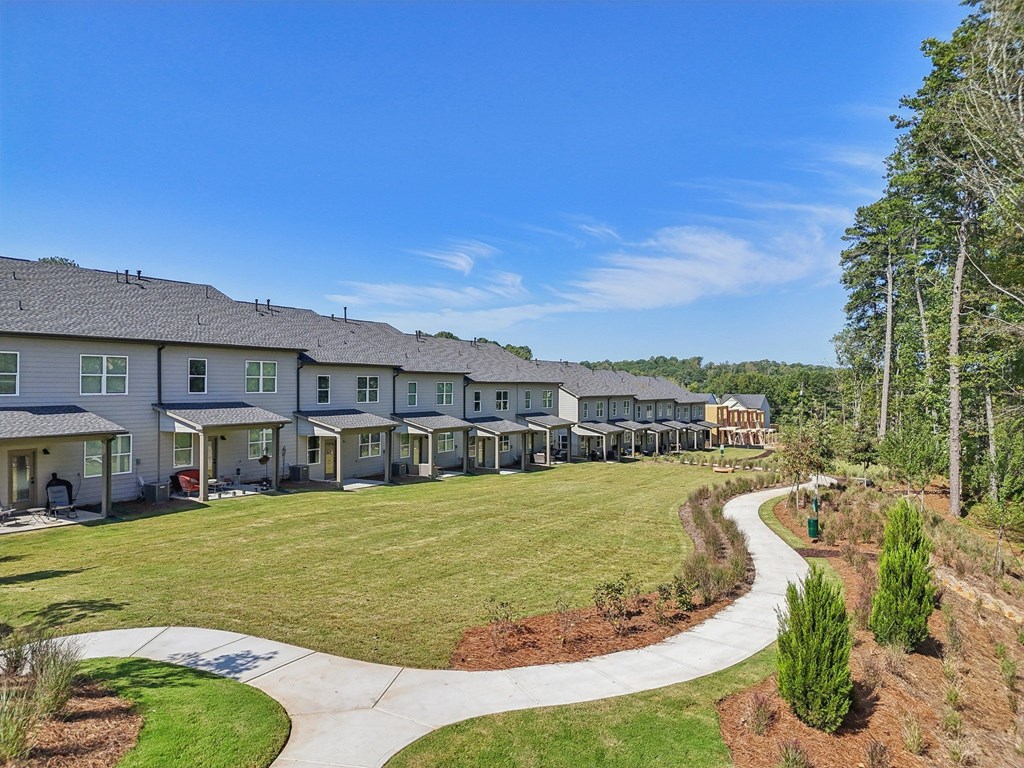A row of houses with a pathway in front of them.
