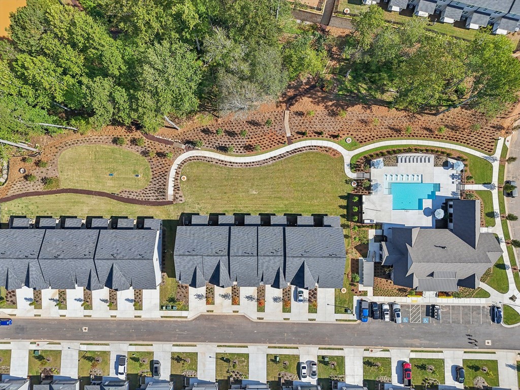 A bird's eye view of a residential area with a swimming pool and apartment buildings.