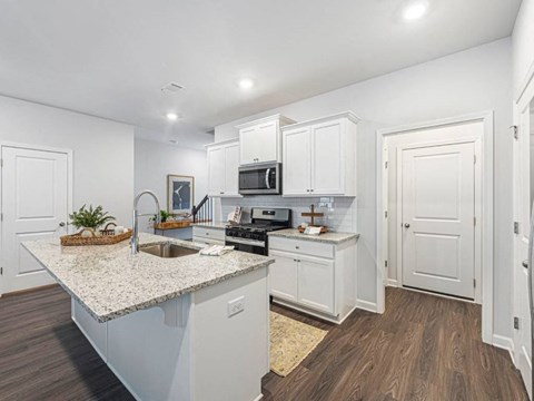 A kitchen with white cabinets and a granite countertop.