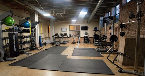 A gym with a variety of equipment including weights and exercise mats.