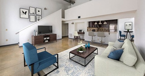 A living room with a blue chair and a white couch.