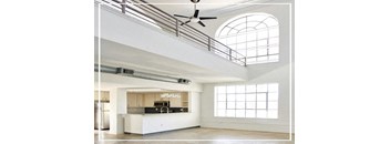 A modern kitchen with a bar area and a ceiling fan.