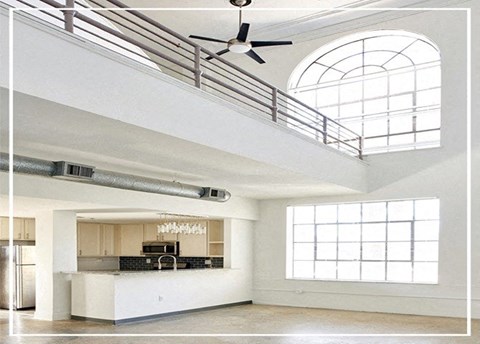 A modern kitchen with a bar area and a ceiling fan.