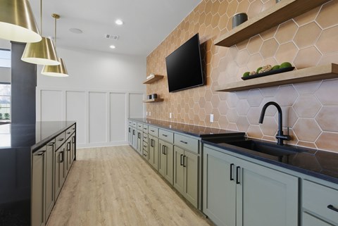 A kitchen with a black counter top and wooden shelves.