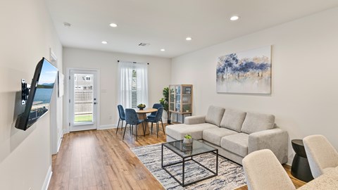 A living room with a grey couch, a coffee table, and a painting on the wall.
