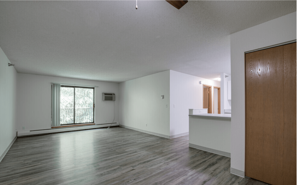 an empty living room with white walls and wood floors