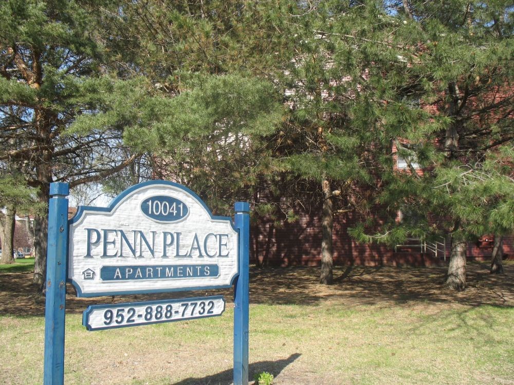 a blue and white sign in a park
