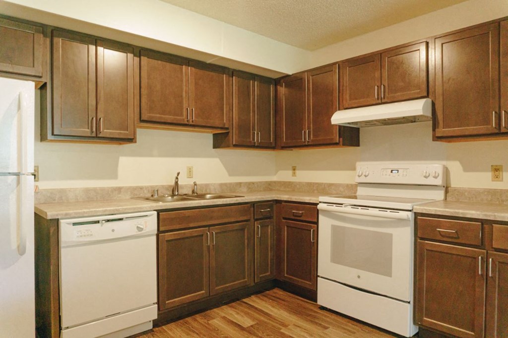 a kitchen with white appliances and wooden cabinets