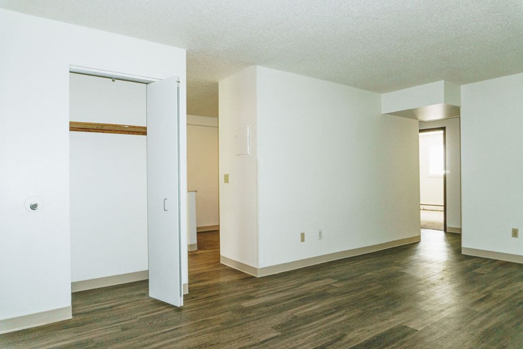 an empty living room with white walls and wood floors