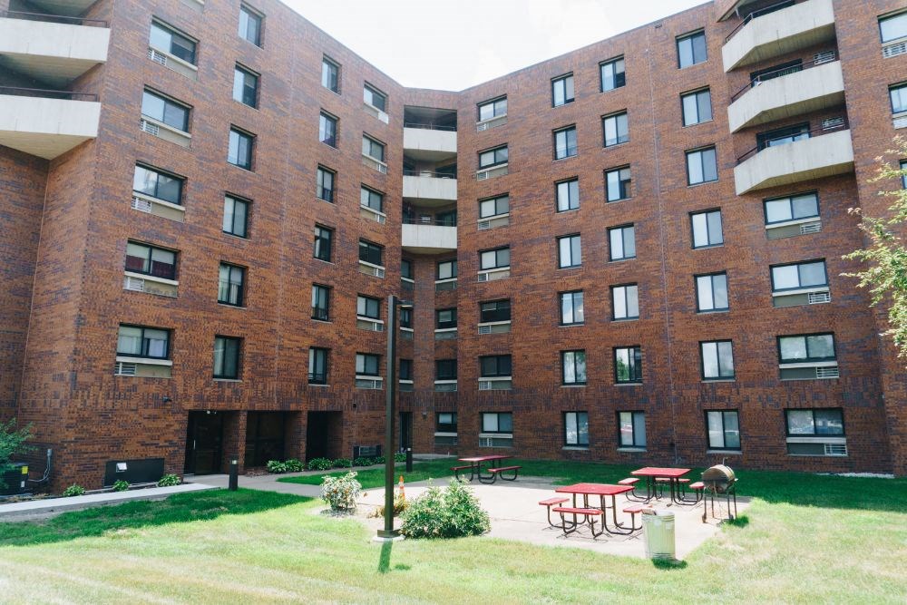 a large brick building with a courtyard in front of it