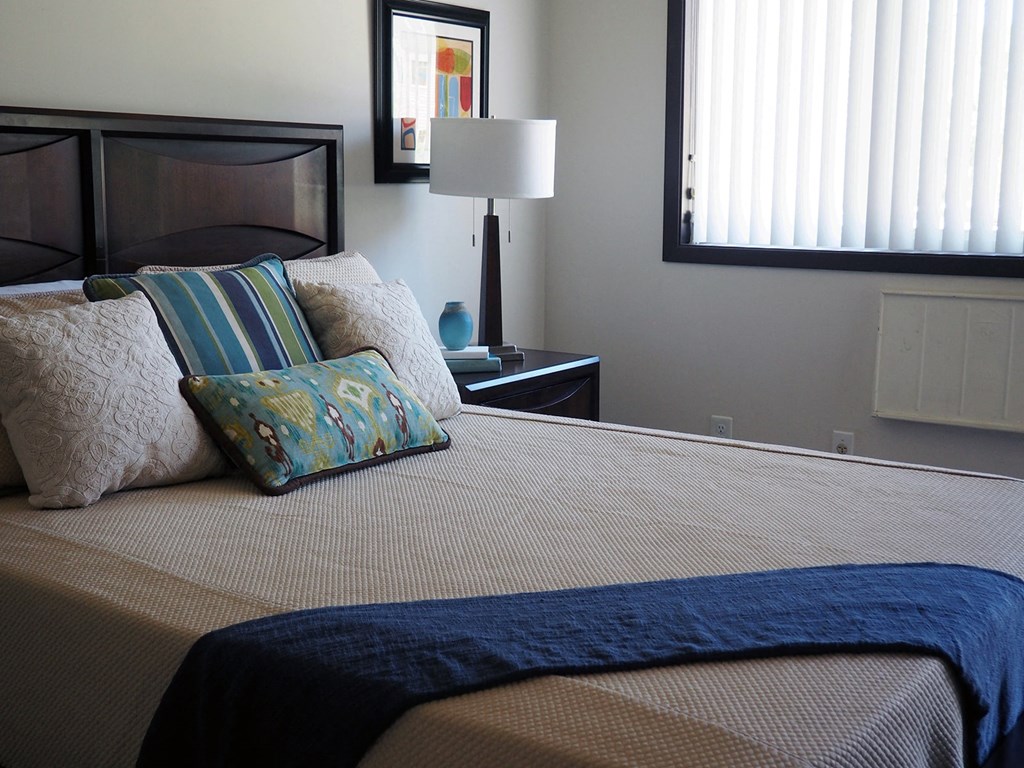 a bedroom with a bed with pillows and a mirror