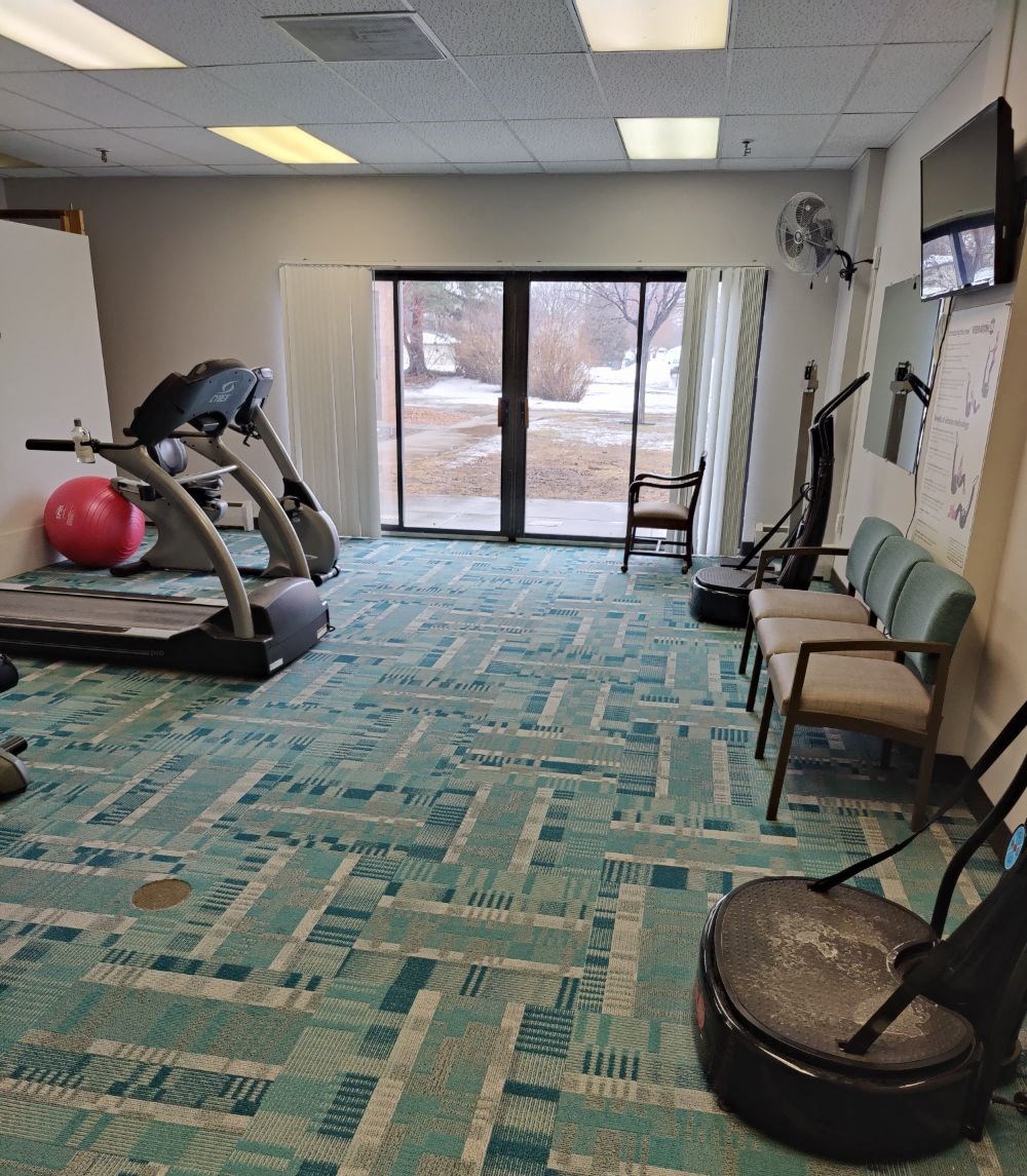 a fitness room with cardio equipment and a sliding glass door