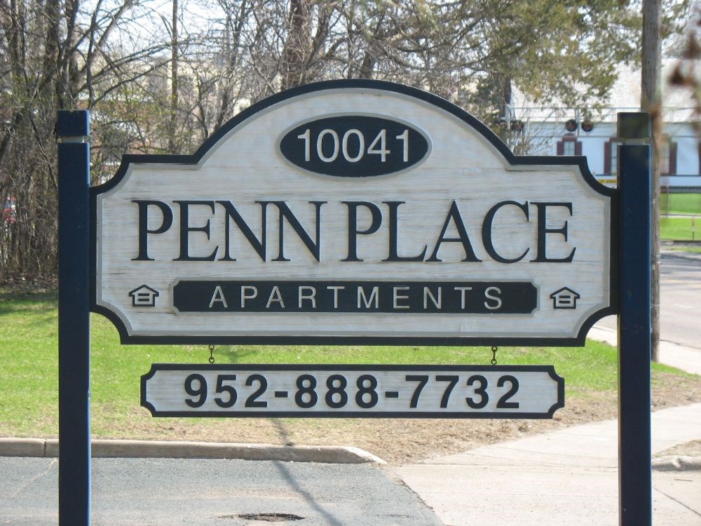a sign for penn place apartments on the side of a street