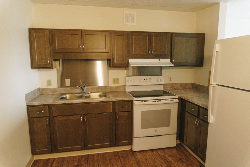 a kitchen with a stove refrigerator and sink