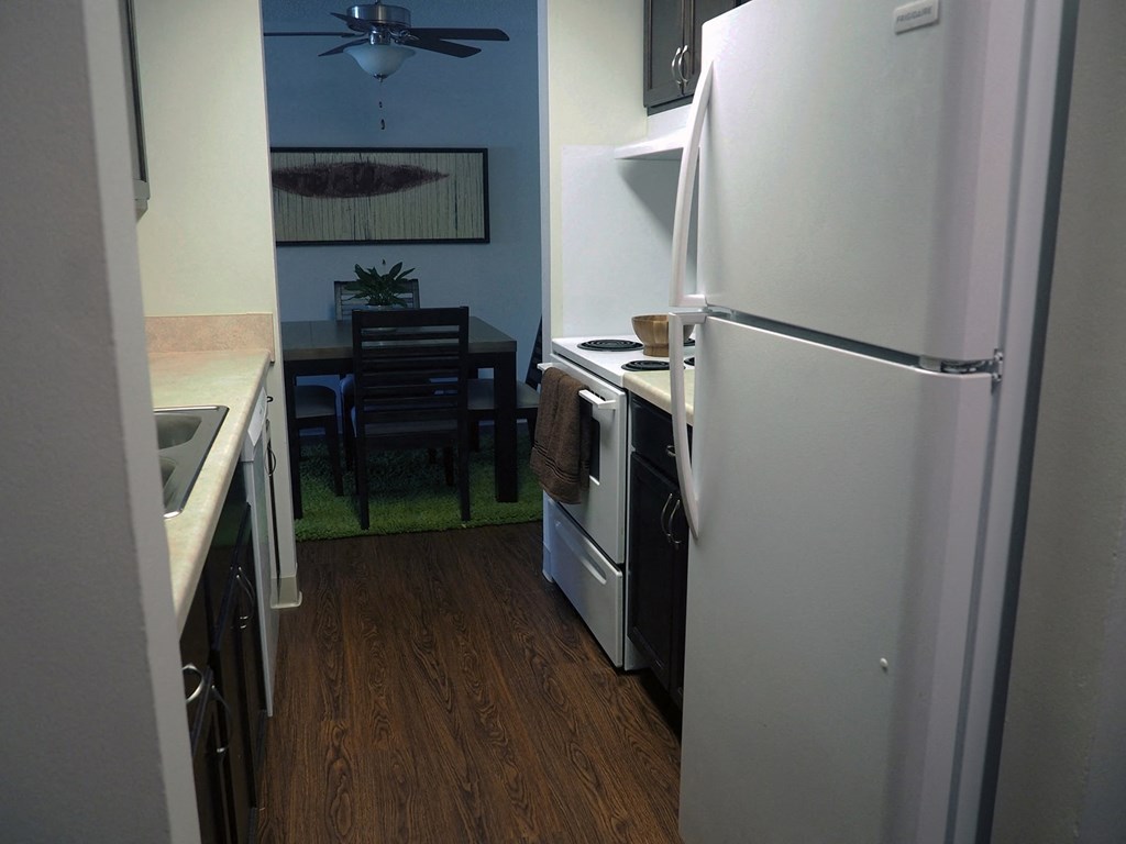 a kitchen with a white refrigerator and a table with a chair