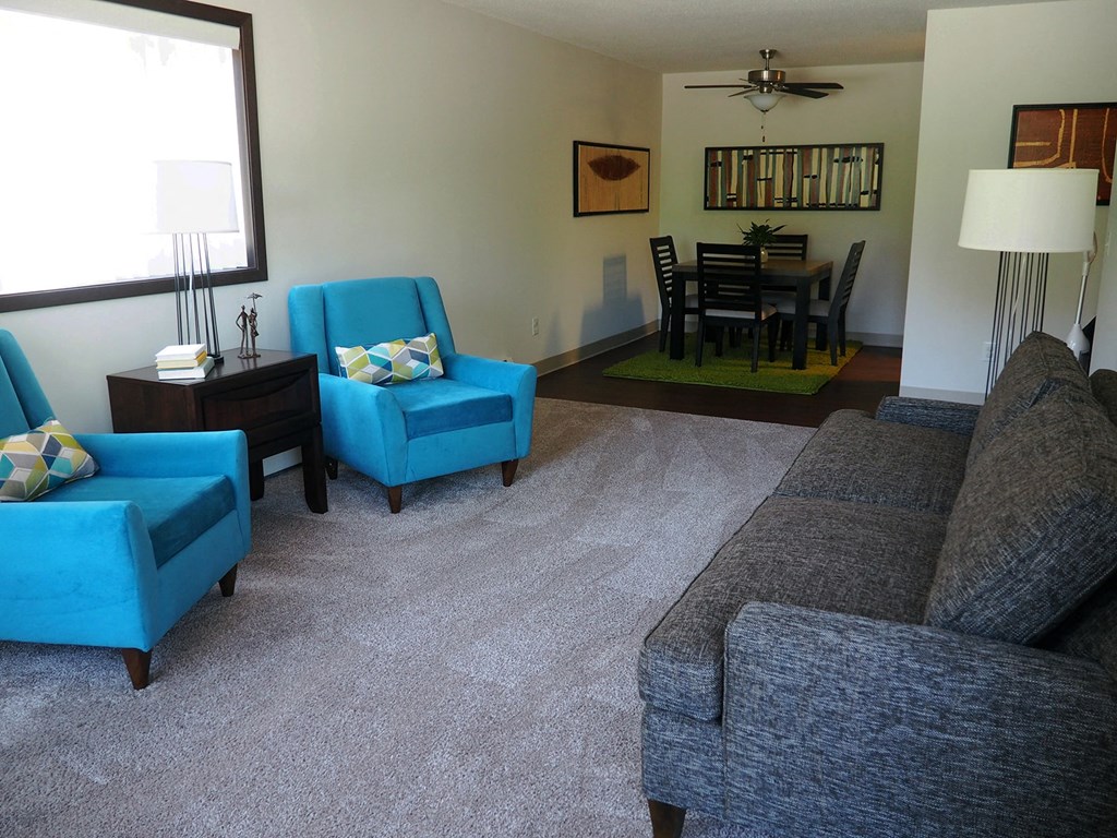 a living room with a couch and chairs and a dining room table