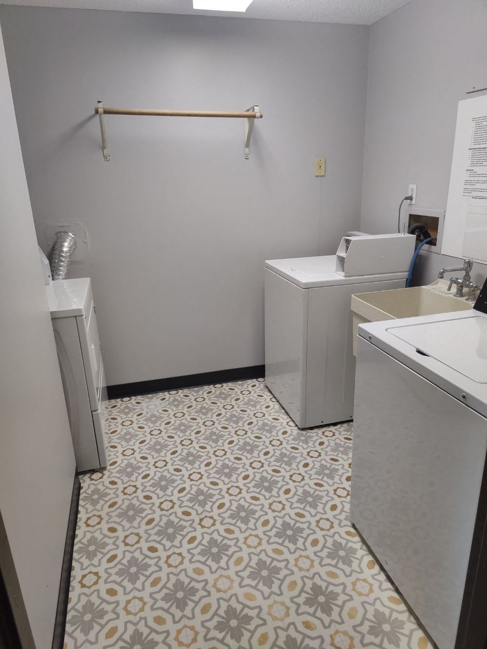 a laundry room with two washing machines and a sink