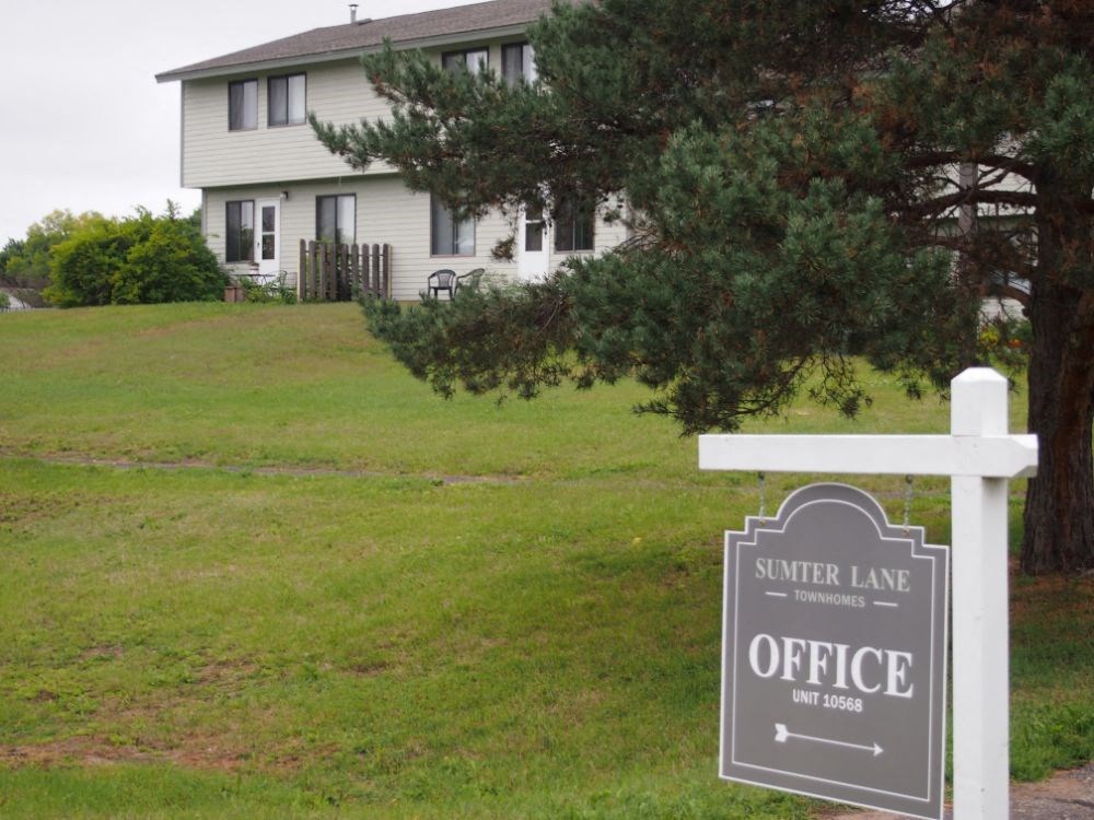 a sign in front of a house with an office sign