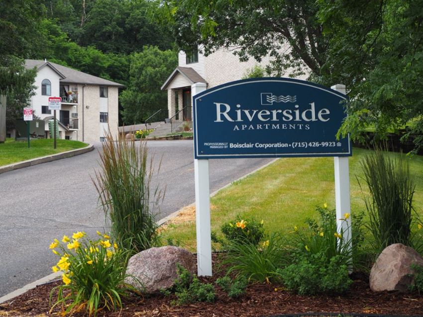 a sign for riverside apartments in front of a road