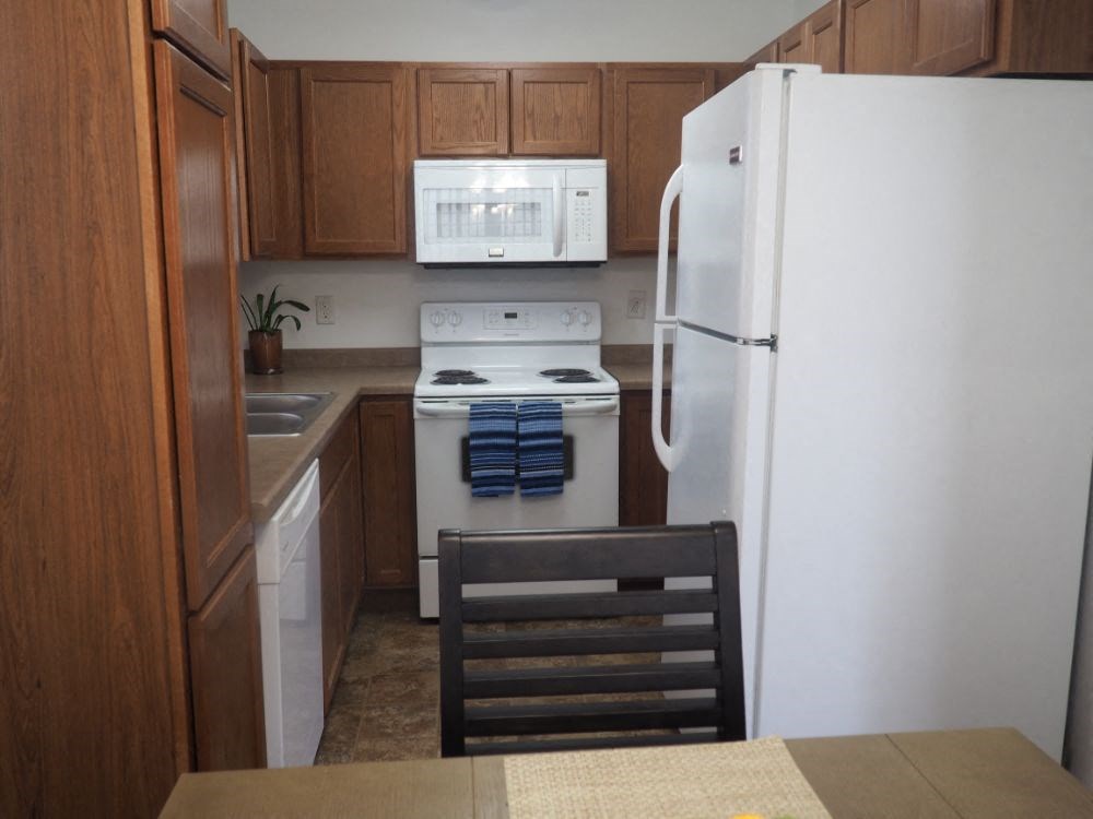a kitchen with white appliances and wooden cabinets
