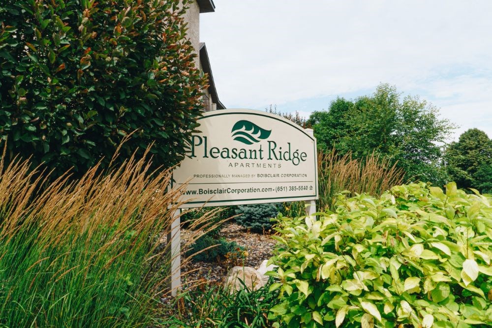 a sign for pleasant ridge landscaping in front of a house