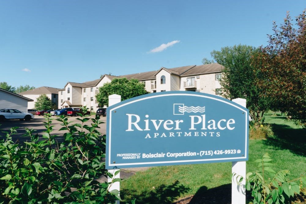 a sign that reads river place apartments in front of some houses