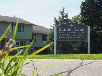 a sign for summer lane townhomes in front of a house