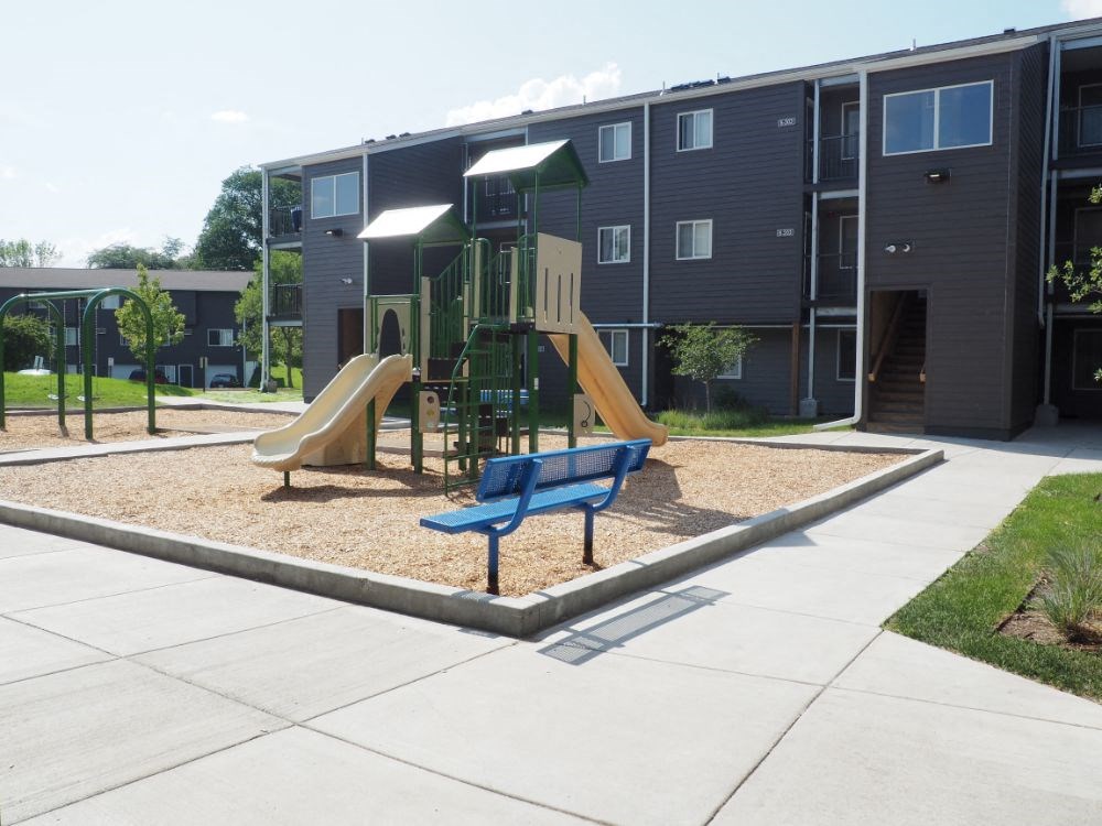 a playground is shown in the courtyard of an apartment building
