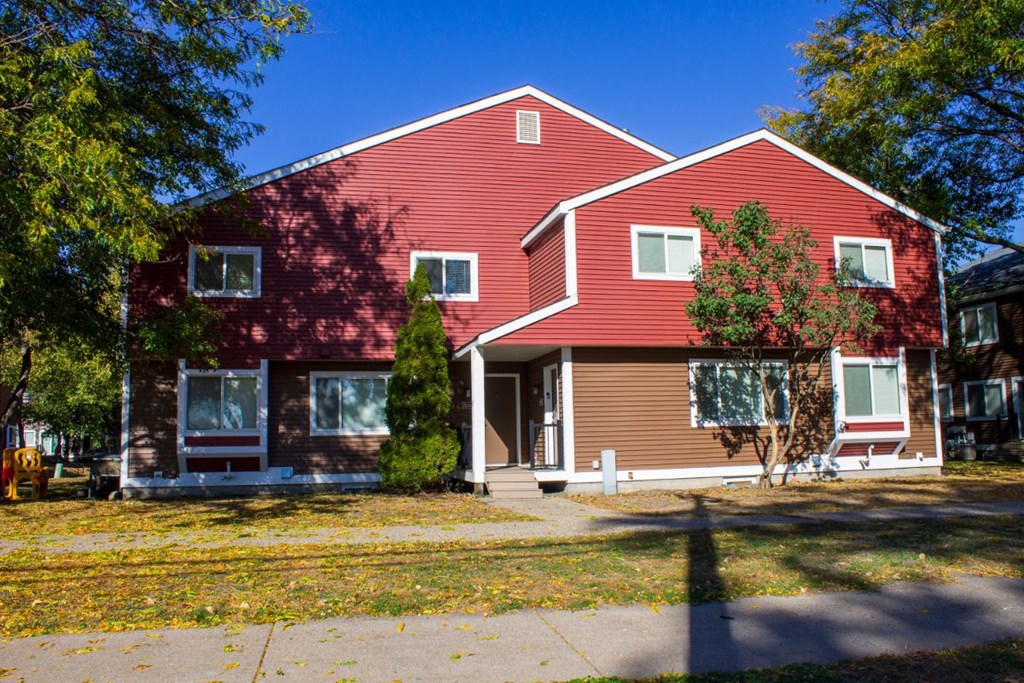 a red house with a sidewalk in front of it