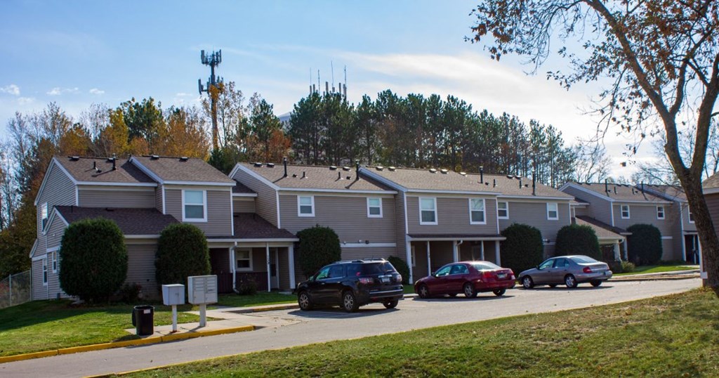 an apartment building with cars parked in front of it