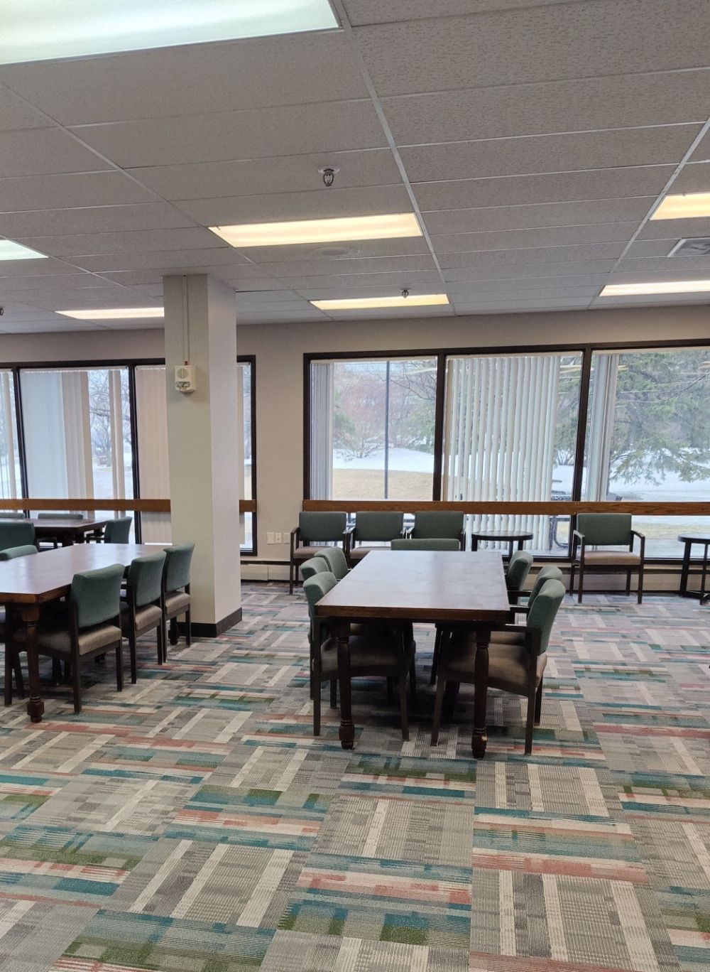 a large dining room with tables and chairs and large windows