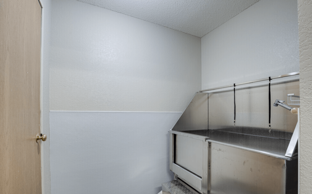 an empty room with a sink and a door