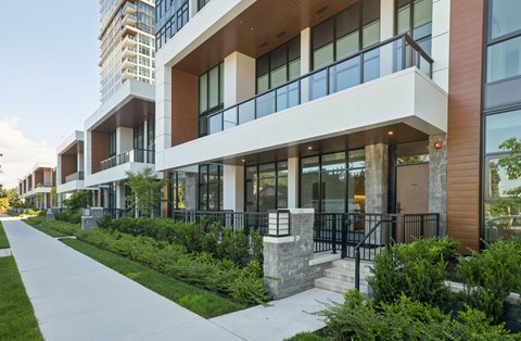 A modern building with a balcony and a walkway in front.