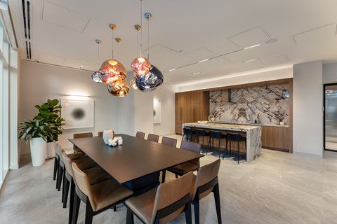 A modern dining room with a large table and chairs.
