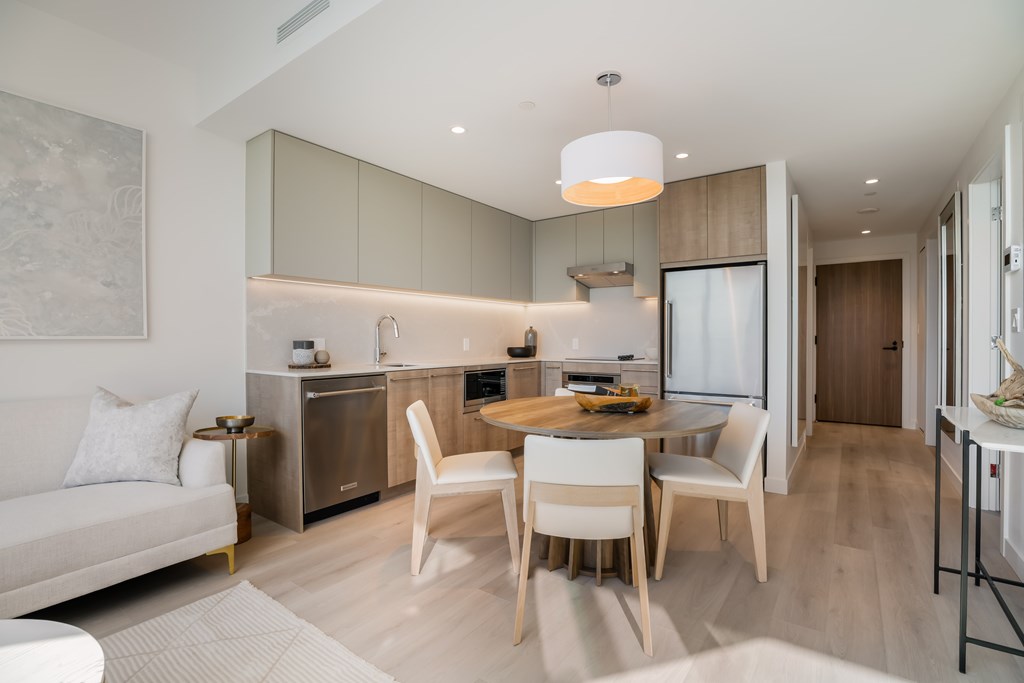 A modern kitchen with a dining table and chairs.