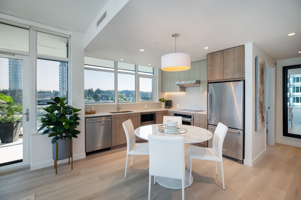 A modern kitchen with a dining table and chairs.