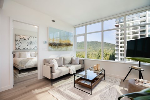 A living room with a couch, a coffee table, and a painting on the wall.