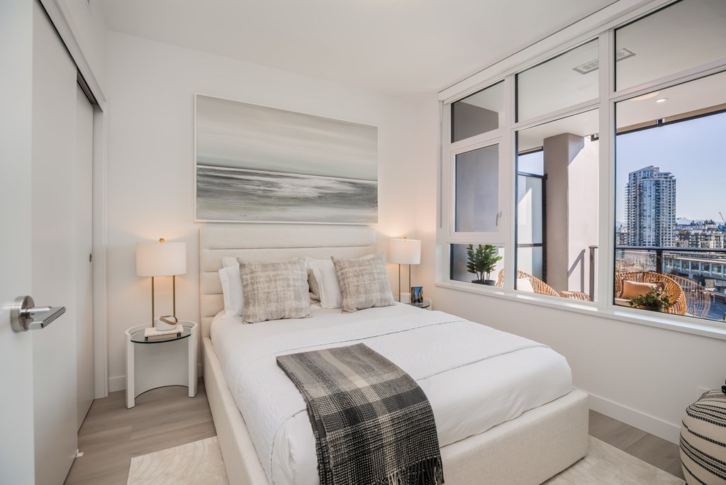 A bedroom with a large bed and a view of the city.