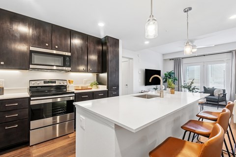 A modern kitchen with dark wood cabinets and a white island.