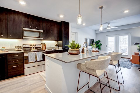 A modern kitchen with dark wood cabinets and white countertops.
